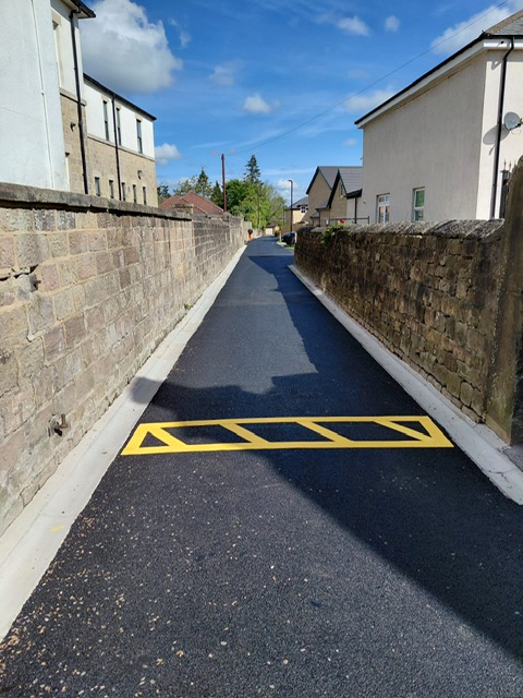 Highway hatch markings on a newly surfaced adopted road