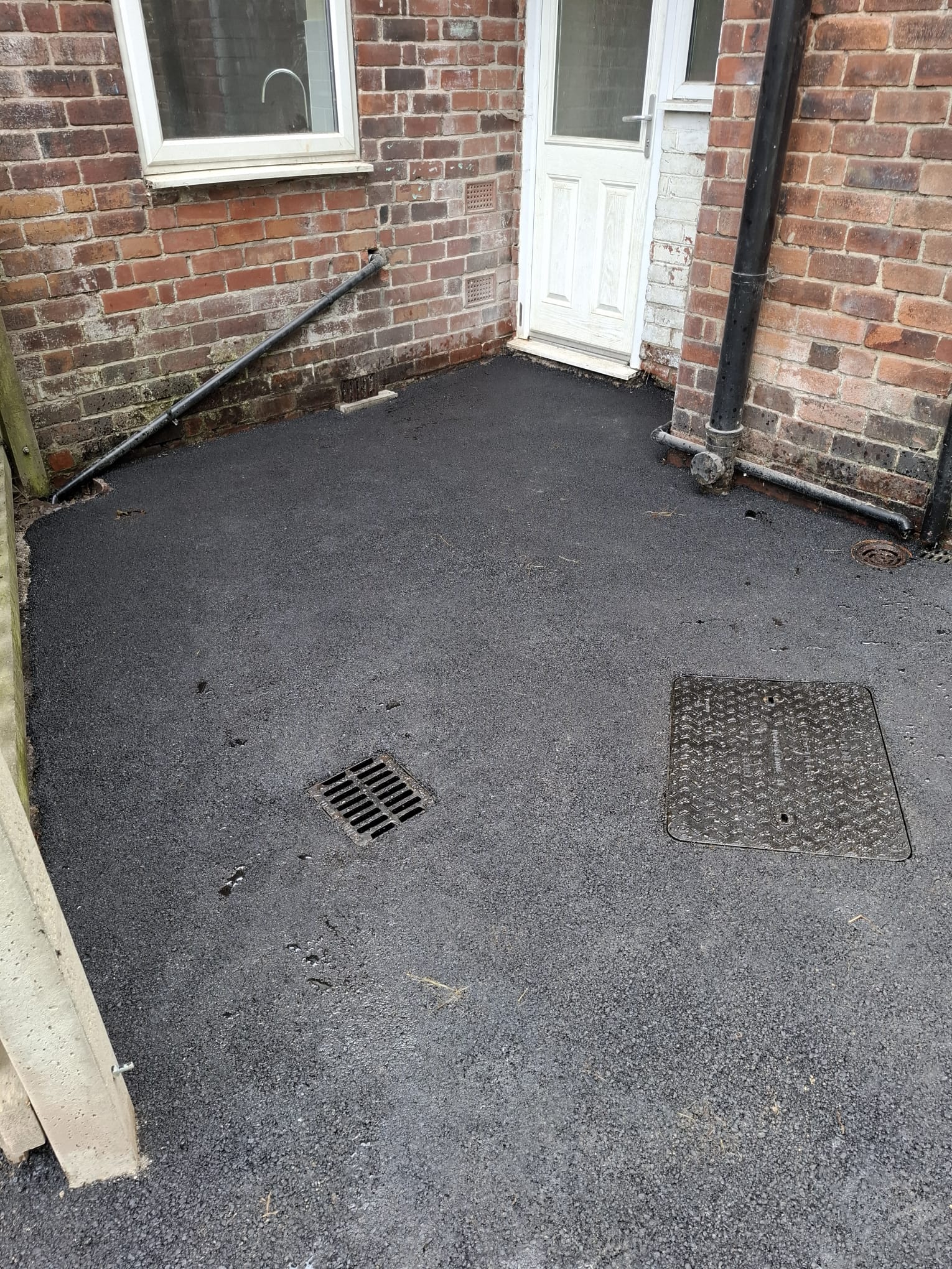 Tarmac yard surfacing laid around existing drainage gullies